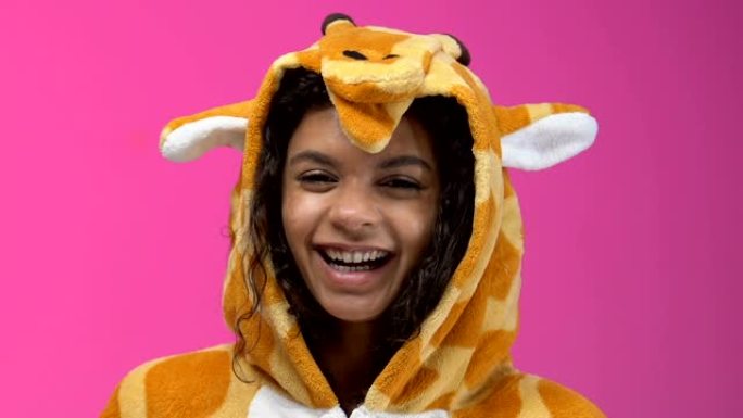 穿着长颈鹿睡衣的非洲裔美国女孩吃爆米花和看喜剧节目