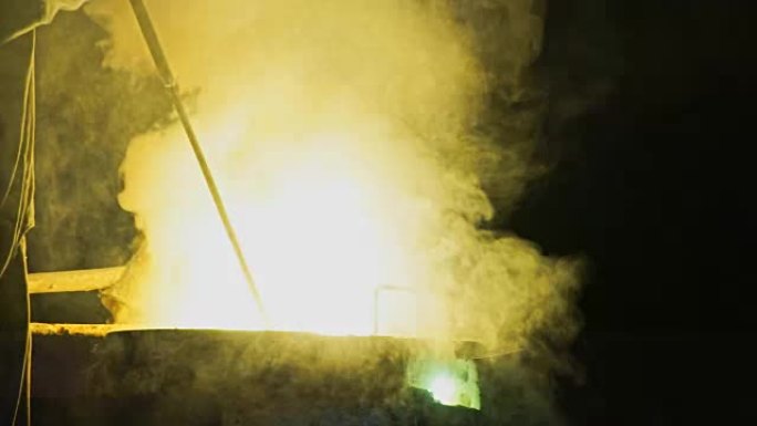 高炉冒出的分层白烟和火。在铸铁厂加工钢材。