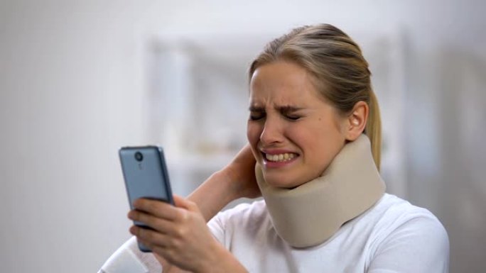 微笑的女人在泡沫颈圈阅读手机上的信息感觉颈部疼痛