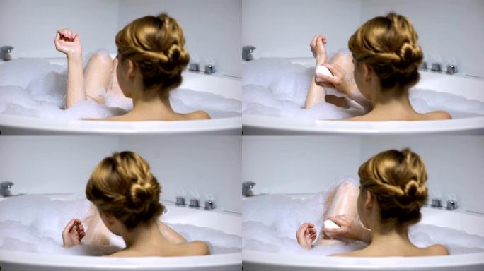 女性在洗澡时用洁面皂清洗身体，美容程序，后视图