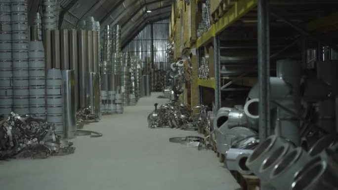 存放在仓库的钢金属管和金属物品。储存在货运站的现成生产。钢铁行业，金属生产，制造业。摄像机从右向左移