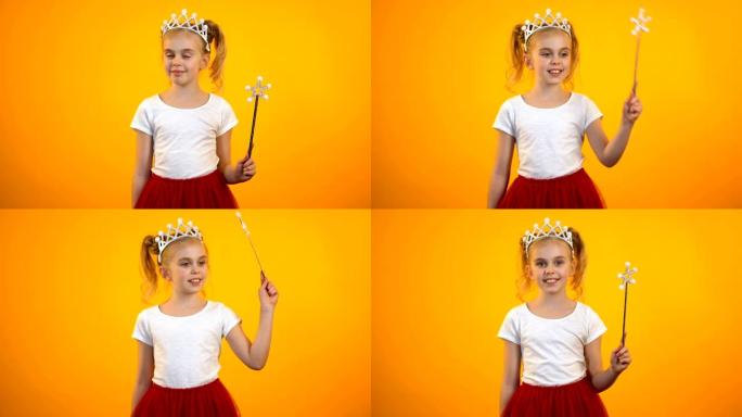 穿着童话服装的有趣女孩用魔杖假装公主运动