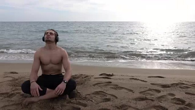 英俊的男人独自在海滩上休息
