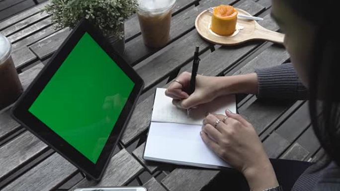 女商人使用数字平板电脑和咖啡店，绿屏