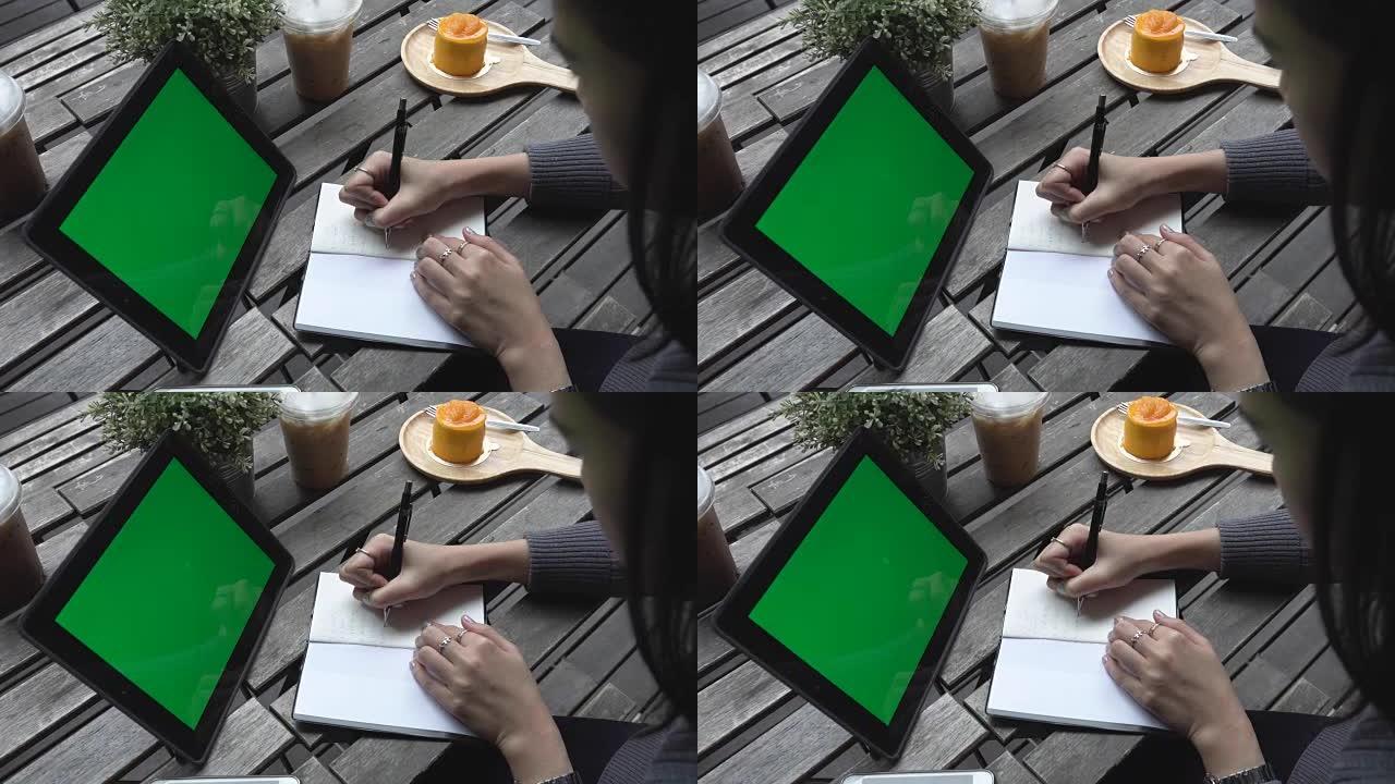 女商人使用数字平板电脑和咖啡店，绿屏
