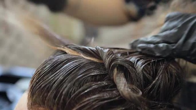 染发。美发师正在用染发剂染发长发。