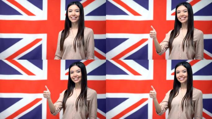美丽的女人在英国国旗背景下竖起大拇指，模板