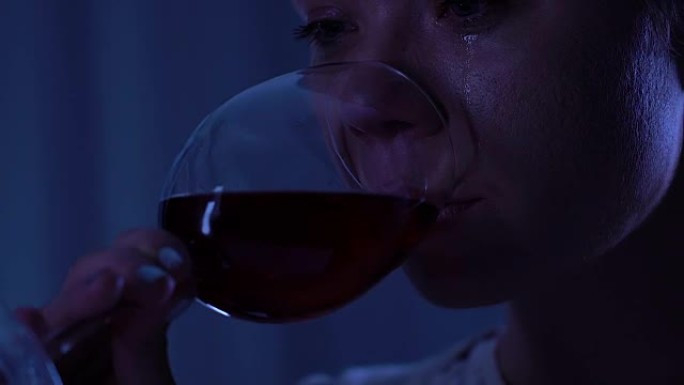 绝望的孤独女人分手后哭泣和喝红酒，沮丧