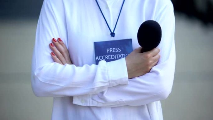 带有麦克风和新闻认证徽章的女人，为记者提供媒体通行证