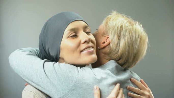 带着癌症微笑的女人拥抱她的女性朋友，希望治愈，支持