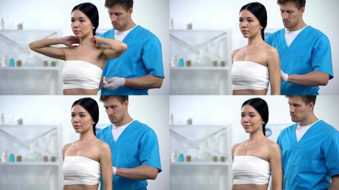 男性整形外科医生应用弹性贴合乳房女性患者，压缩