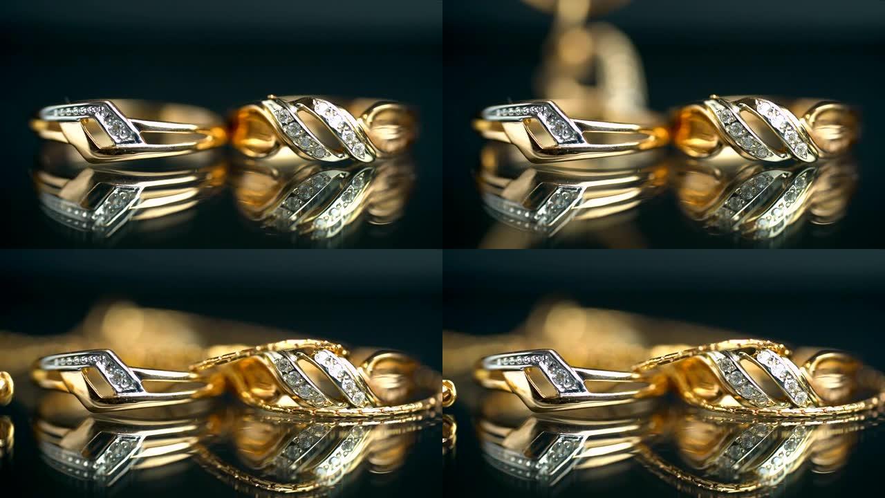 金戒指和链条，反射表面上的珠宝。背景
