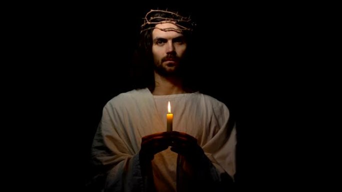 荆棘冠冕上的圣人手持蜡烛，并期待着基督教的摄影