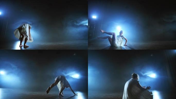 现代芭蕾舞女赤脚做旋转，旋转和舞步，站在舞台上的烟雾慢动作。舞台表演