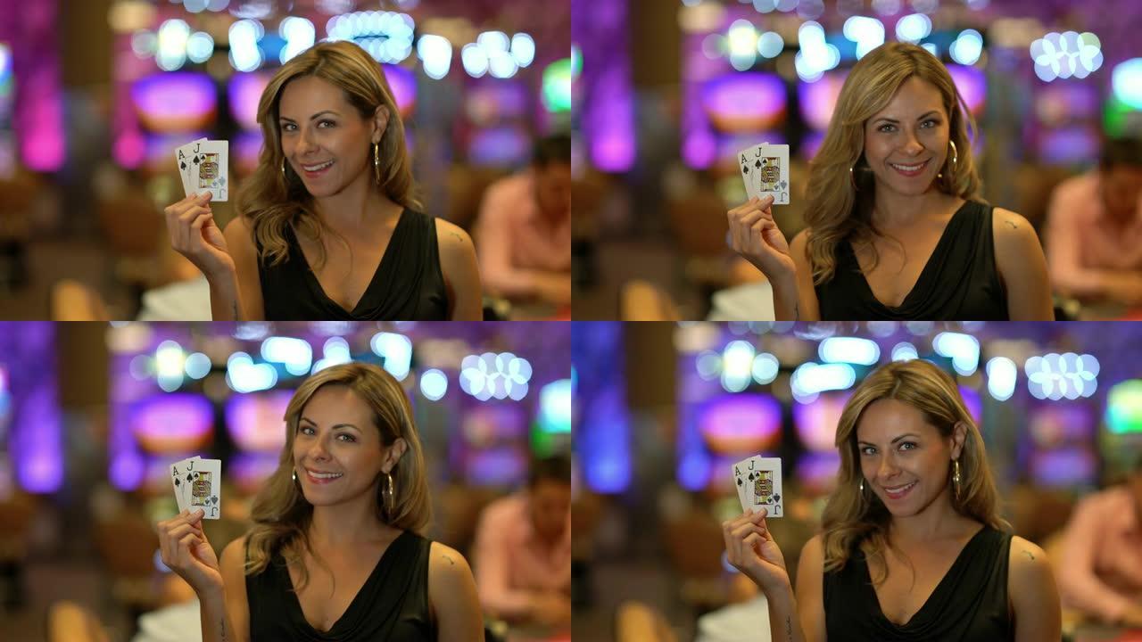 美丽的拉丁美洲年轻女子在赌场对着镜头微笑时拿着卡片
