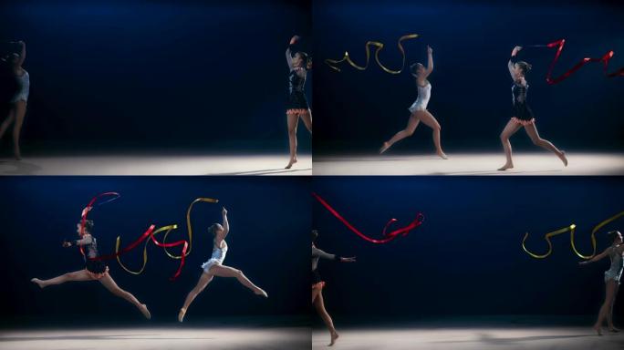 SLO MO两个艺术体操运动员彼此相对，一边旋转丝带一边进行跳跃