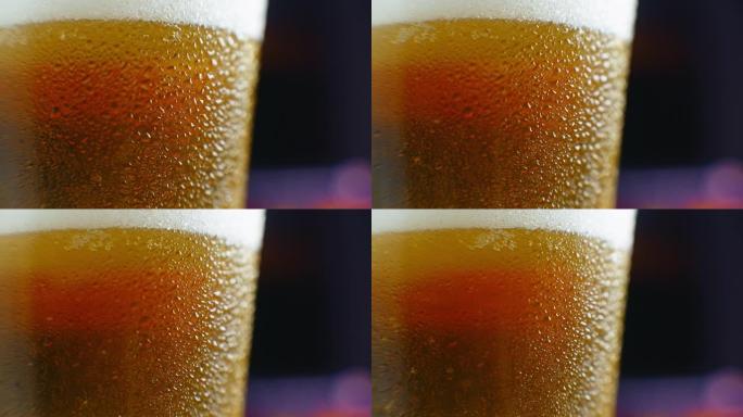 特写慢动作: 冰镇啤酒在玻璃杯中大滴和气泡在啤酒中。