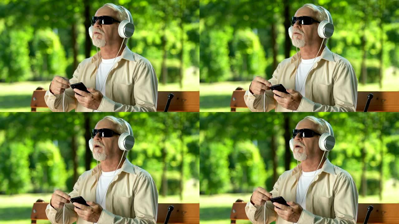 盲人试图将耳机电缆插入智能手机以听音乐