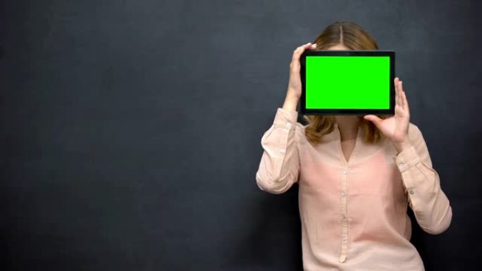 女孩把脸藏在绿屏后面，网上匿名的概念，模版