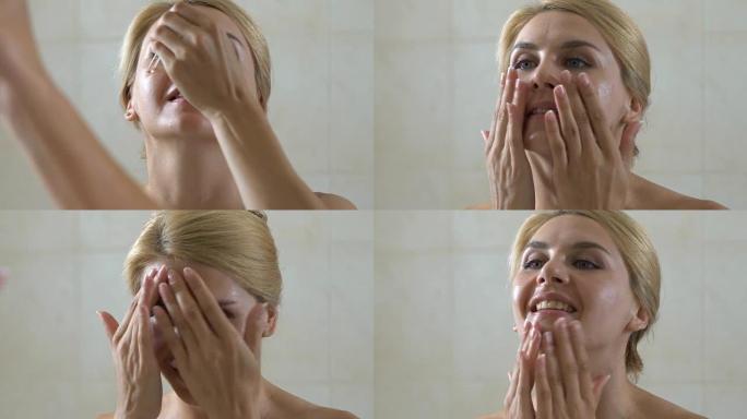 女人在浴室的脸上滴化妆品油，有益的健康酸