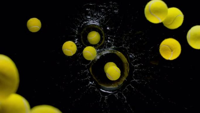 SLO MO LD黄色网球在黑色背景下掉入水中