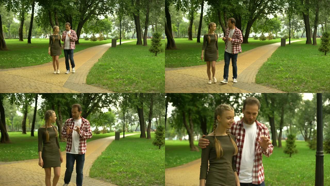 成年父亲与充满爱心的十几岁女儿在公园散步，分享他的生活经历