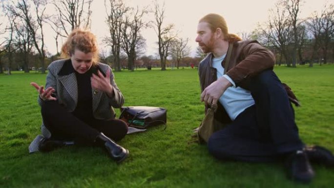 在爱丁堡的草地上进行热烈讨论的男人和女人的手持镜头