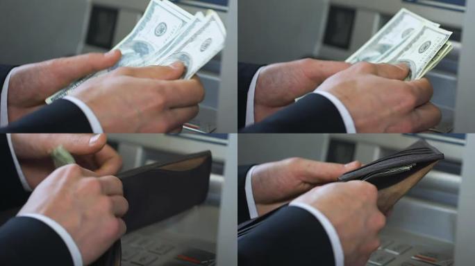 业务人员在自动取款机附近计数美元并将钱放入钱包，银行