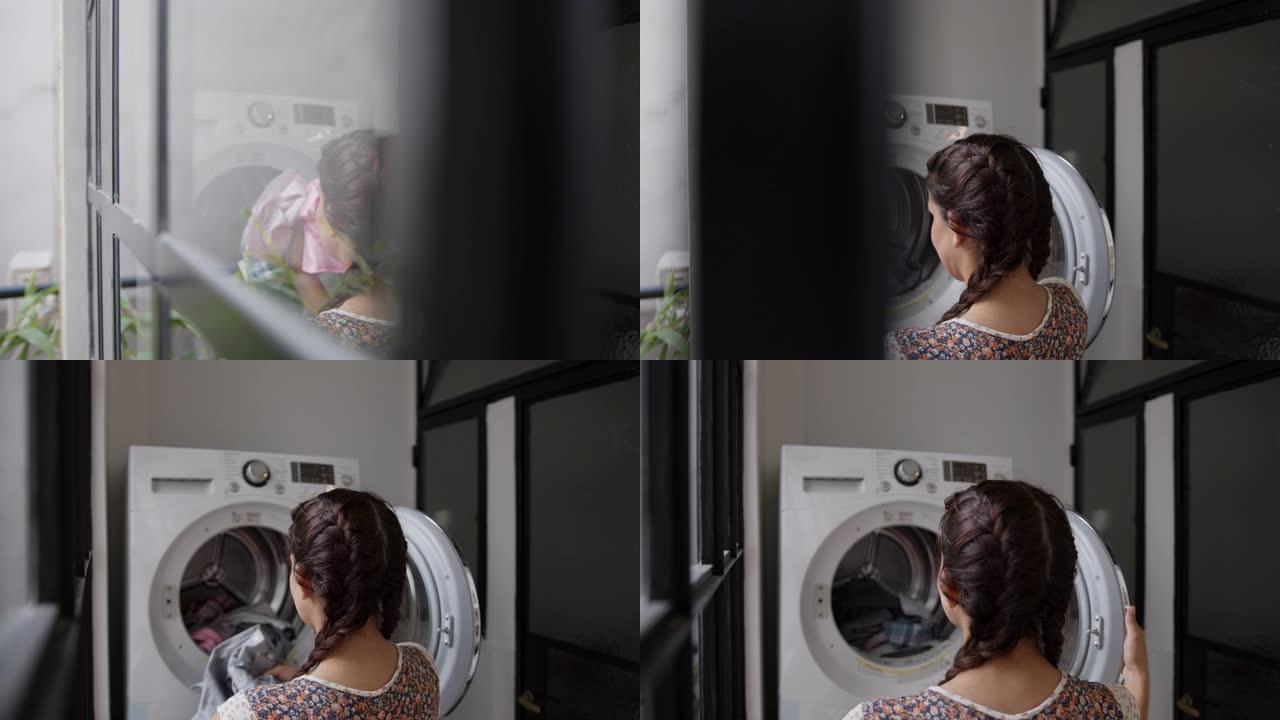 女人在家里给烘干机加衣服的慢动作