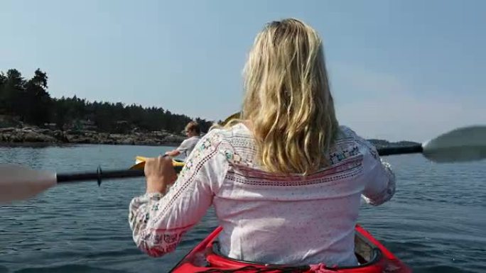 女人在宁静的水域划桨海洋皮划艇