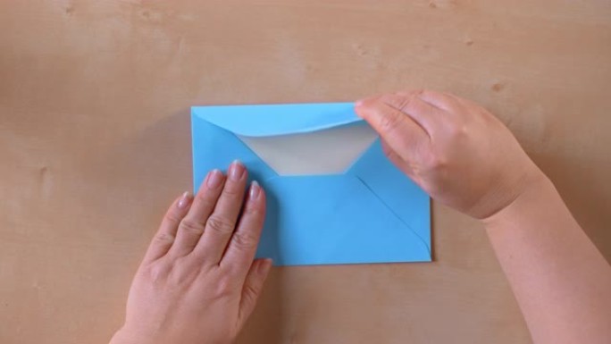 SLO MO LD双手打开蓝色信封并取出一张纸