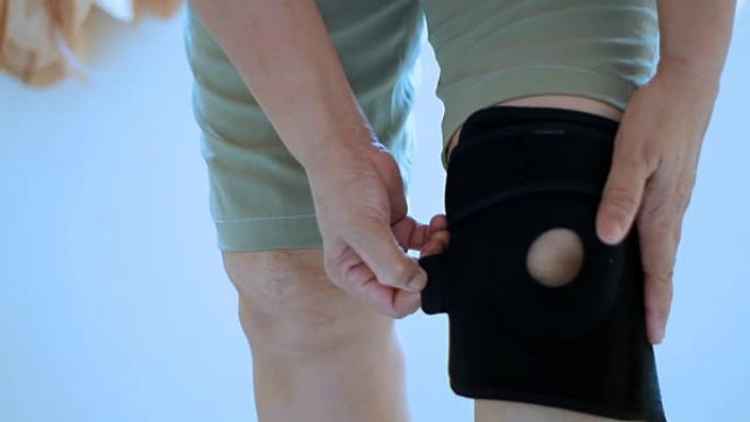 亚洲女性膝盖受伤，并在腿上使用膝盖支撑支架