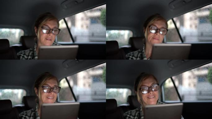 使用数字平板电脑在出租车内工作的女人-肖像