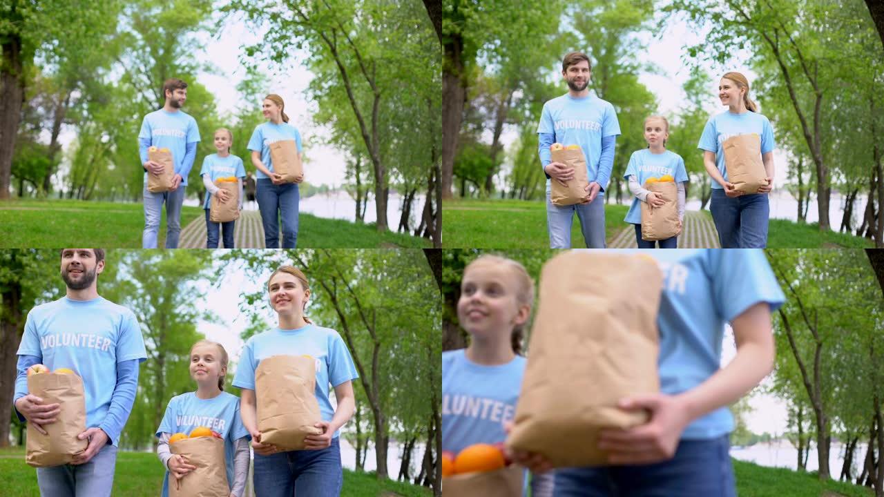 志愿者家庭步行公园拿着装有苹果和橘子的纸袋，帮助