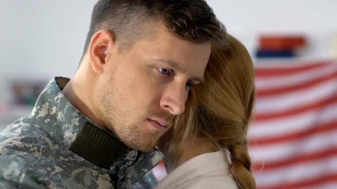 悲伤的军人丈夫拥抱着女友，看着镜头的特写，永别了
