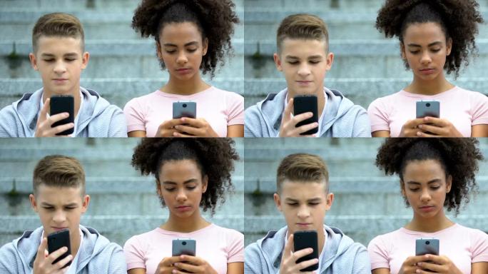 混血女性和不高兴的白人男性青少年在手机上玩游戏
