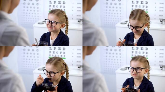 眼科医生给可爱的小女孩蓝莓，眼睛用天然维生素