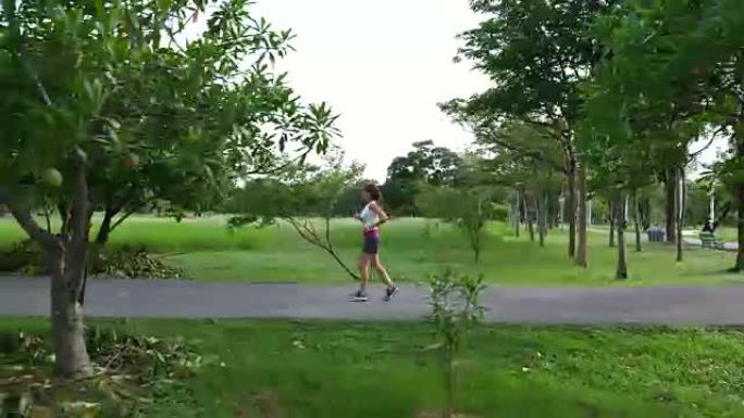 亚洲妇女在公园的绿色环境中奔跑