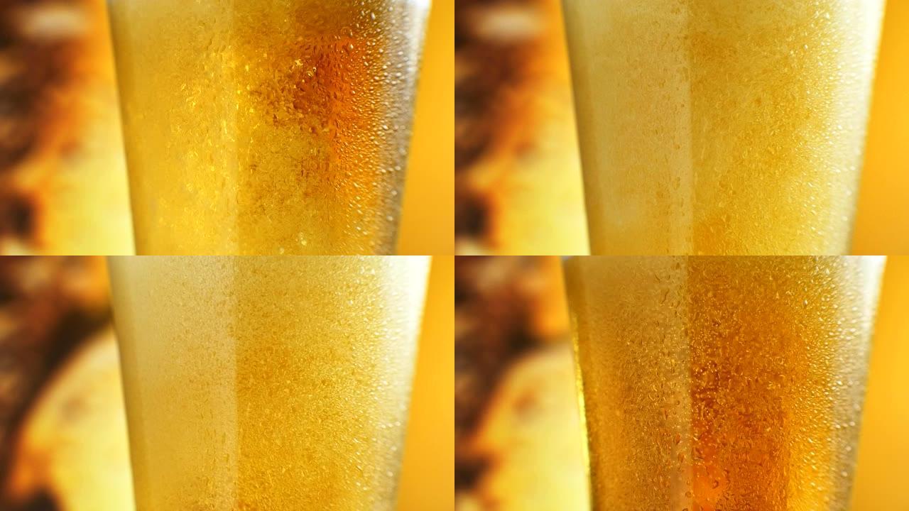 啤酒正在倒入有角度的玻璃杯中。点击IPA。装有水滴的玻璃杯中的冷淡啤酒。精酿啤酒形成波浪关闭。新鲜和