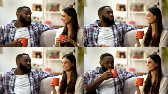年轻的混血夫妇在家里喝咖啡聊天，交谈愉快