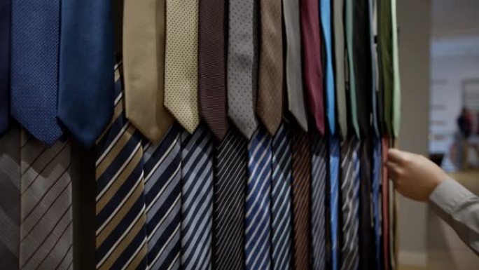 无法识别的男性顾客在男士商店中选择领带的特写镜头