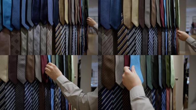 无法识别的男性顾客在男士商店中选择领带的特写镜头