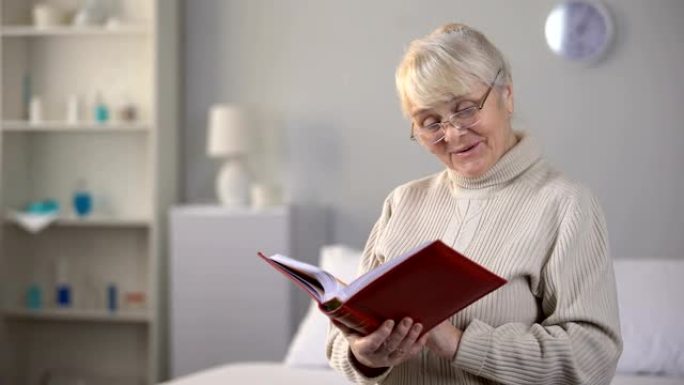 微笑的戴眼镜的老年妇女看相册，美好的回忆，家庭