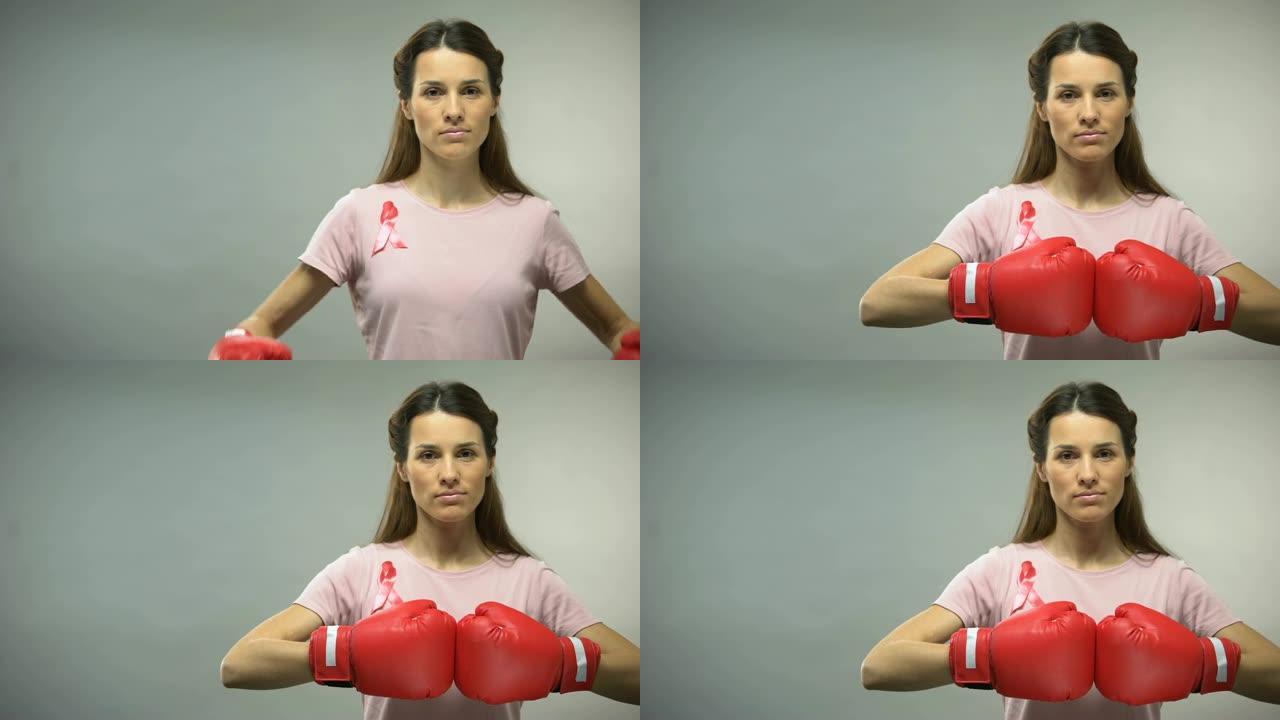 女人用粉色丝带在拳击手套，对抗乳腺癌的概念