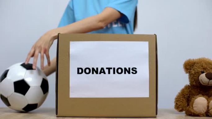 妇女将衣服和玩具放在捐款箱中，社会志愿项目
