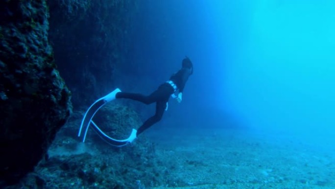 潜水潜水员从洞穴中游泳的水下慢动作镜头