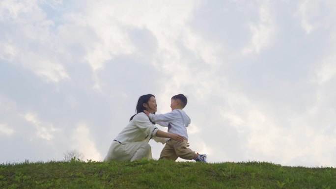 拥抱小孩年轻妈妈怀抱草地奔跑温馨家庭教育