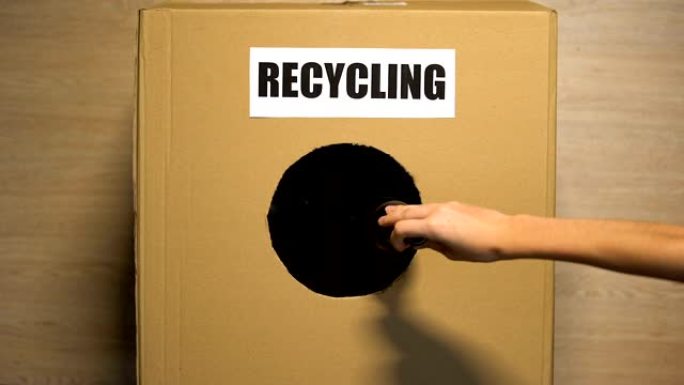 回收纸板箱上写的字，人们的手扔可重复使用的垃圾