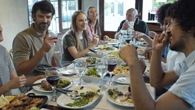 微笑和大笑的家人在阿根廷Parrilla餐厅用餐