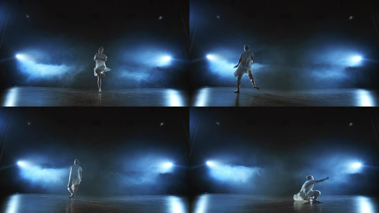 变焦相机用软件和烟雾将女舞者穿过舞台。一个现代戏剧芭蕾，一个穿着白色连衣裙的女人在一条腿上旋转并跳跃